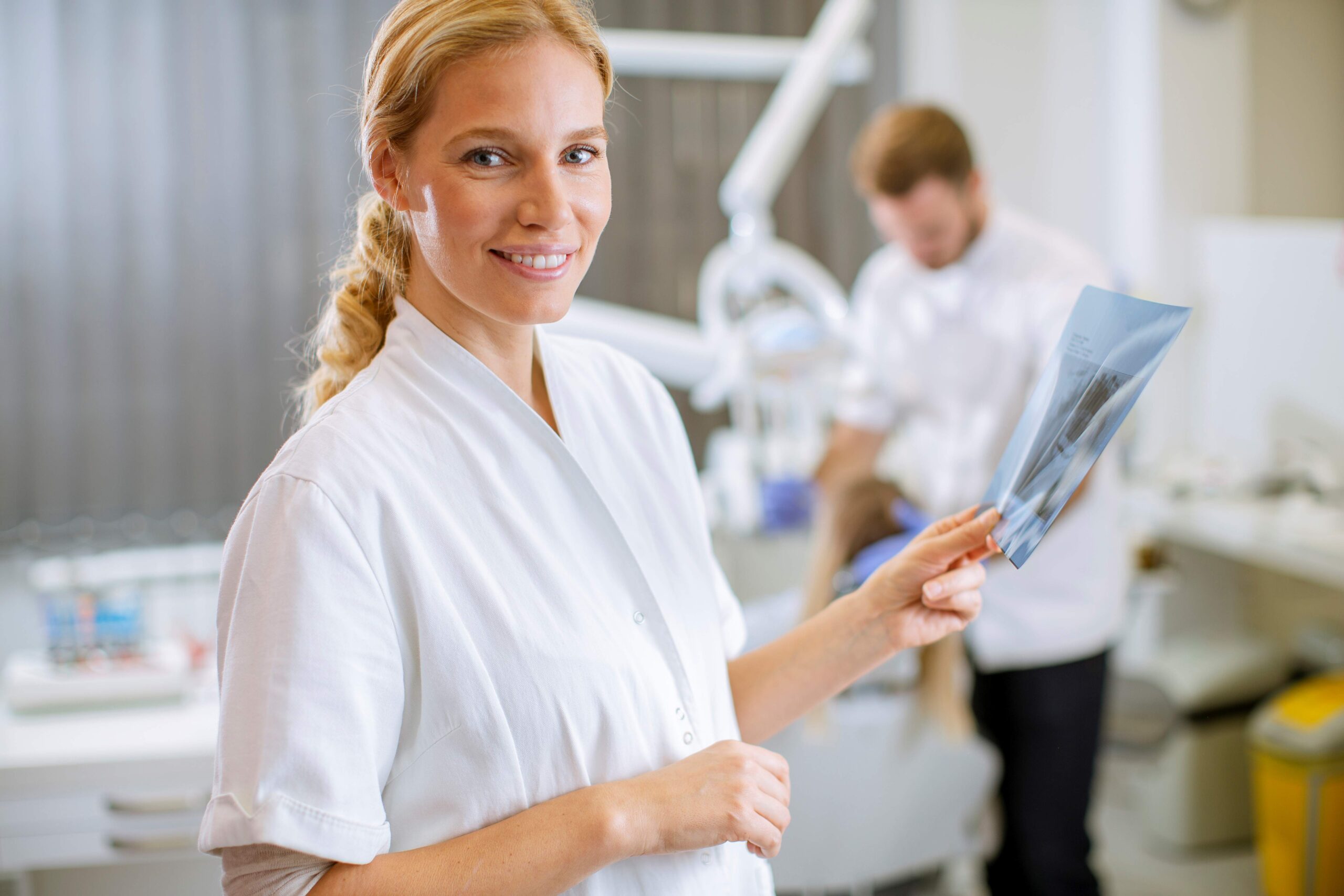 44645062-female-dentist-examining-the-x-ray-for-the-treatment