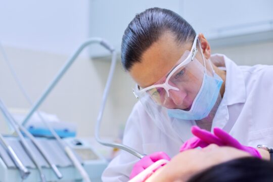 37926115-experienced-dentist-treats-teeth-in-patient-care-and